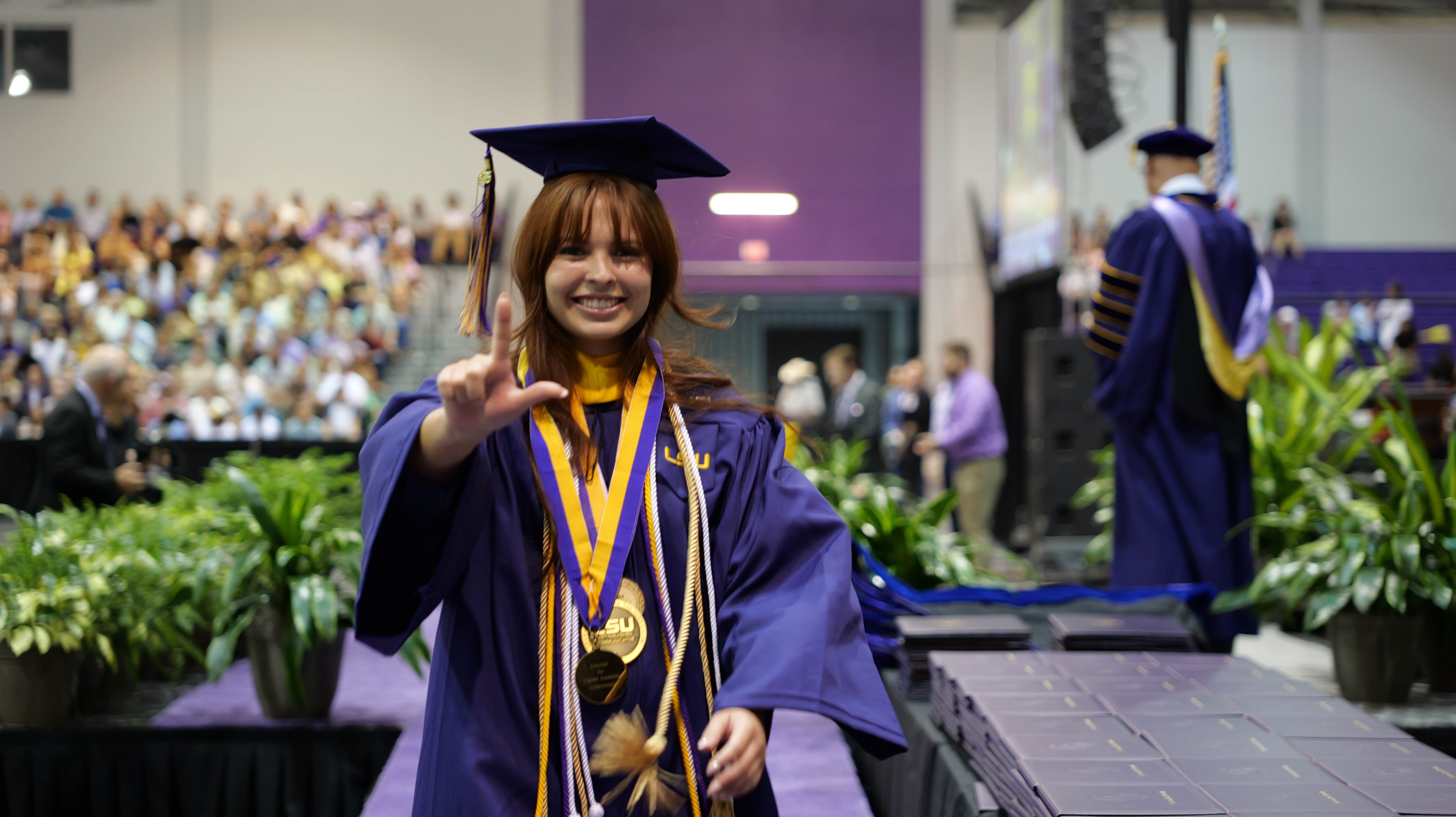 Allison Huddleston throws up an L after receiving her diploma Placeholder Image