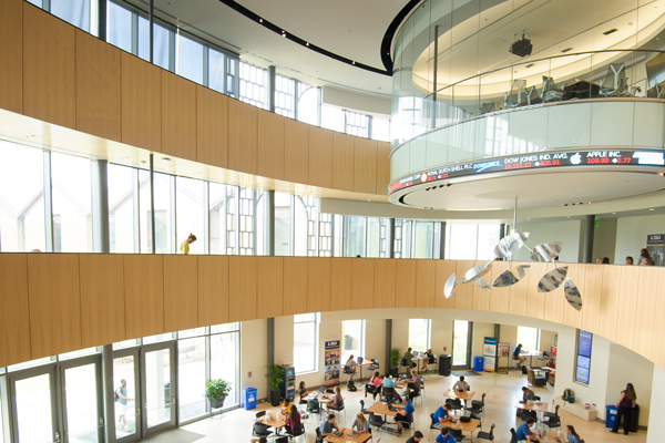 Viewed from the second floor, the BEC Rotunda is full of students studying and chatting at tables on a sunny day. 