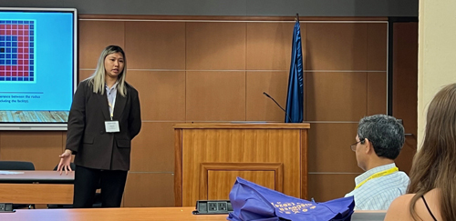 Vivian Liu wears a suit and gives a presentation on rain in industrial areas.