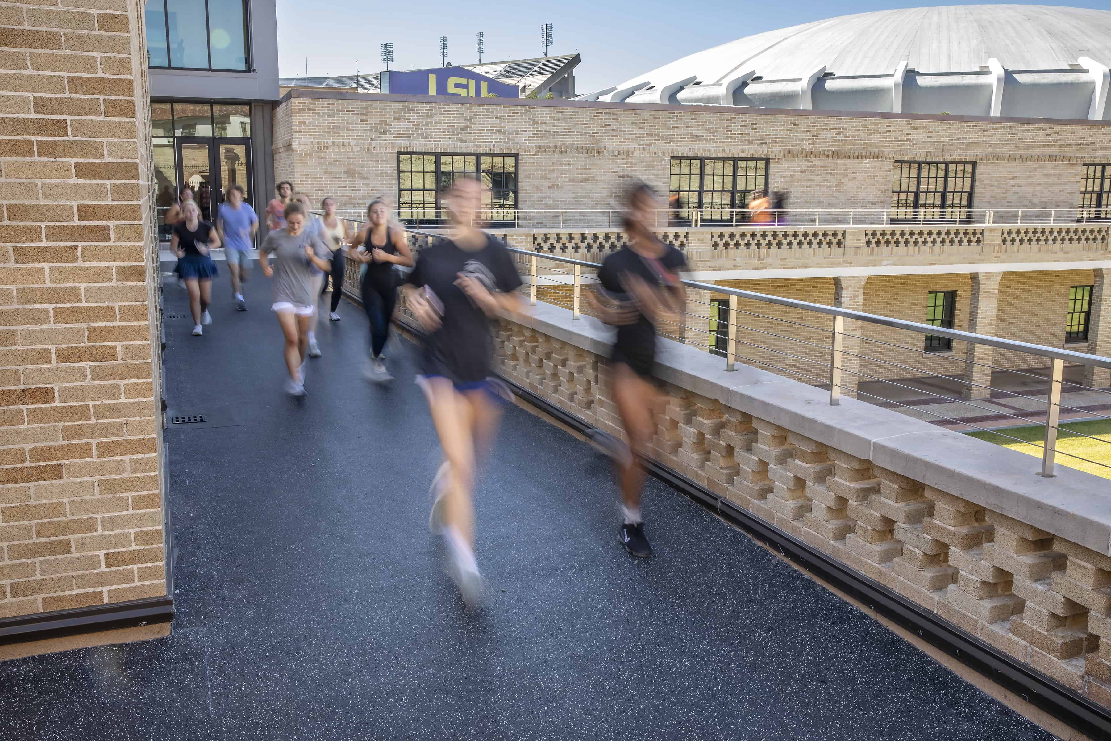Students running around the track at the Huey P. Long Field House
