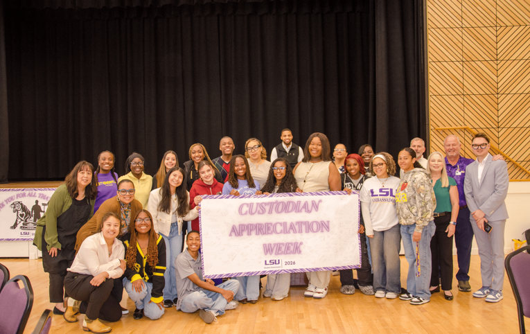 group standing with banner group standing with banner