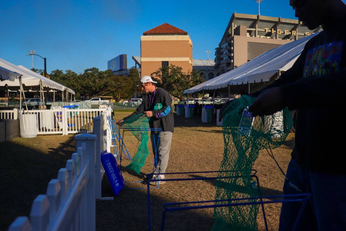 A photo of a volunteer setting up clear stream bins for Gameday Challenge.
